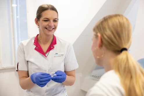 Assistent laat onzichtbare beugel aan patiënt TopOrtho Zwolle zien